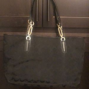 Black Coach purse with logo and leather trim.